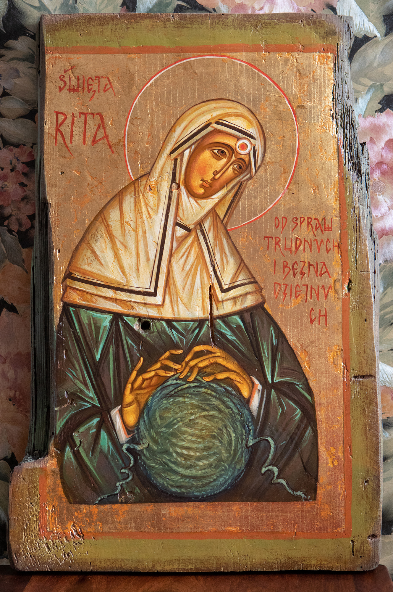 Saint Rita with the attribute of thorn (from the Savior's crown of thorns), embedded deeply in her forehead. The Saint is untangling the 'Gordian knot' in the shape of sphere.