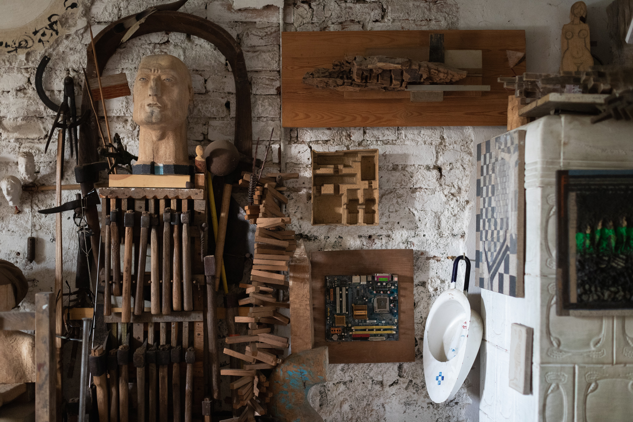 Zbliżenie na narzędzia pracy Maćka Pęcaka, min. kolekcję siekier, których używa do tworzenia drewnianych rzeźb.